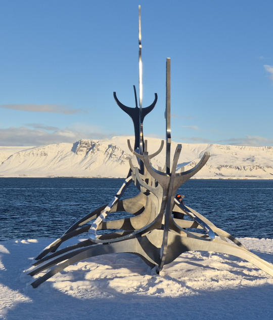 Sun Voyager sculpture in Reykjavík in winter with snow, ocean views, and mountains in the background