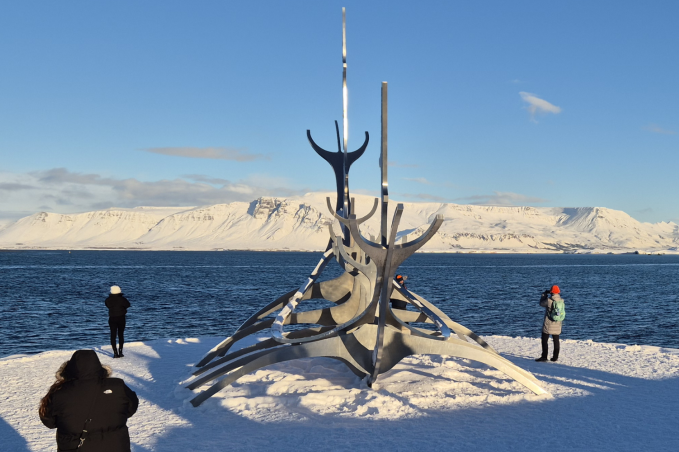 Sun Voyager sculpture in Reykjavík in winter with snow, ocean views, and mountains in the background