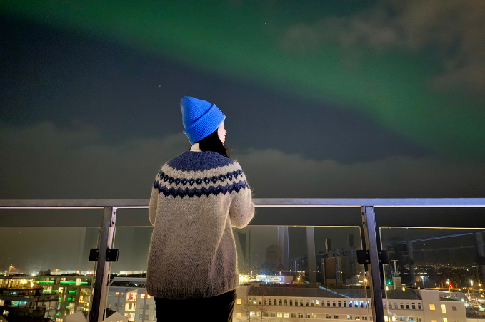 Guest watching the northern lights over Reykjavík from the center hotels plaza rooftop