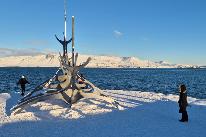 People wearing warm winter layers by the Sun Voyager in Reykjavík in February