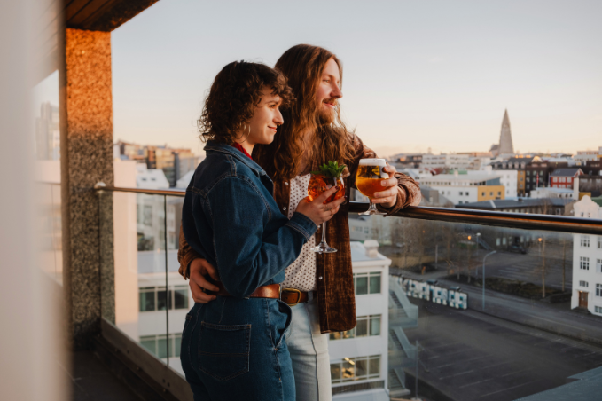 Couple enjoying drinks together with views over Reykjavík on Valentine’s Day