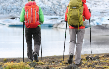Hikers exploring Icelandic glacier landscape near a glacial lagoon