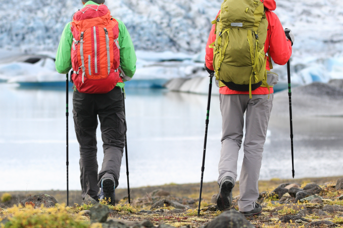 Hikers exploring Icelandic glacier landscape near a glacial lagoon