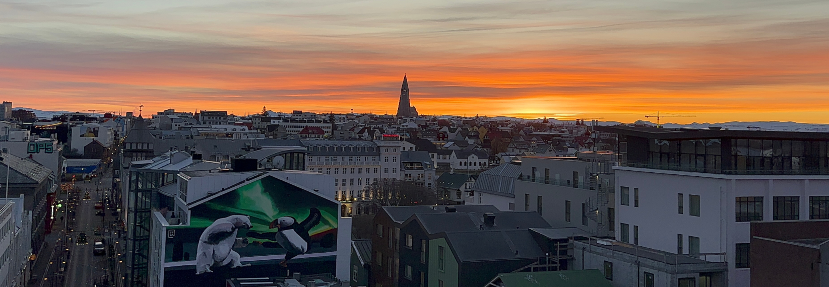 View of Reykjavik Iceland at sunset with Hallgrimskirkja church, colorful rooftops, and city skyline from above