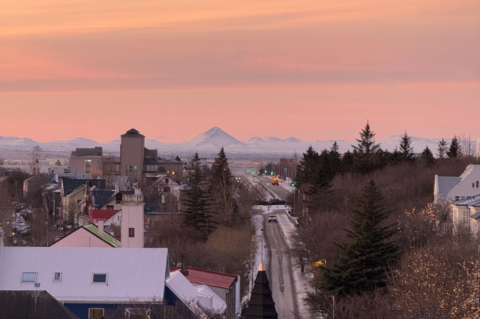 Sunset over Reykjavík with mountain views in the distance.