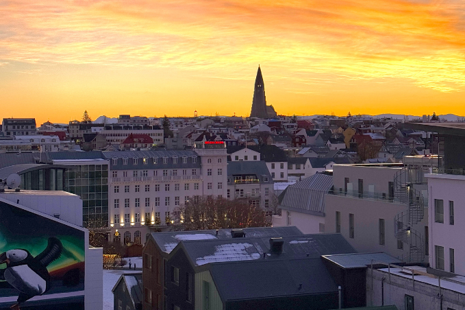 Colorful sunset over Reykjavík with Hallgrímskirkja rising above the city skyline.