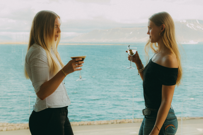 Guests enjoying drinks with panoramic views from SKÝ Lounge & Bar in Reykjavík.