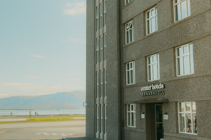 Exterior of Center Hotels Arnarhvoll in central Reykjavík with views towards Faxaflói Bay and surrounding mountains.