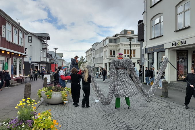 Giant puppet performers entertaining visitors during a street festival on a pedestrian street in central Reykjavík.