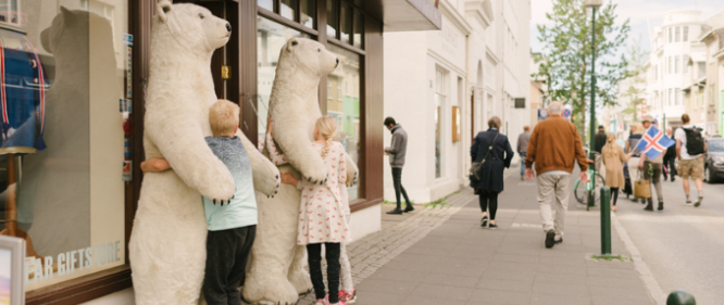 Stuffed fake polar bears being hugged by two children on laugavegur shopping street in reykjavik city center
