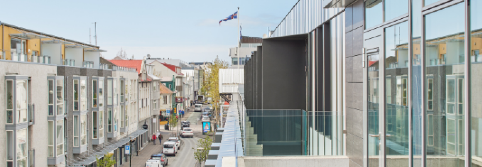 laugavegur street in reykjavik, seen from center hotels laugavegur showing the icelandic flag, street, houses and cars from the third floor