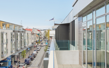 laugavegur street in reykjavik, seen from center hotels laugavegur showing the icelandic flag, street, houses and cars from the third floor
