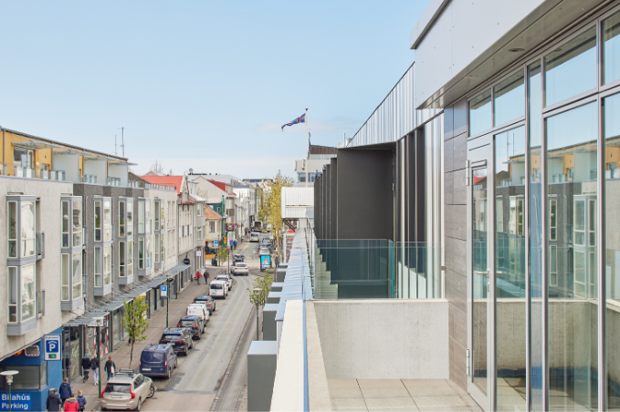 laugavegur street in reykjavik, seen from center hotels laugavegur showing the icelandic flag, street, houses and cars from the third floor