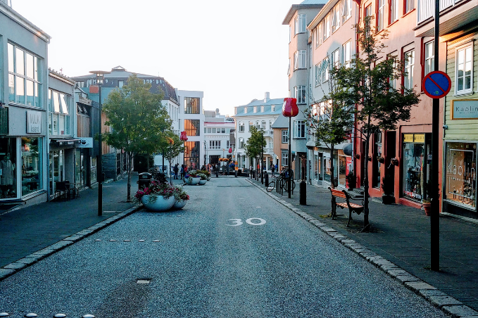 laugavegur street in reykjavik including a few houses, signs and trees