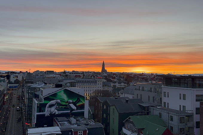 Colorful sunset over downtown Reykjavík with Hallgrímskirkja rising above the city skyline.