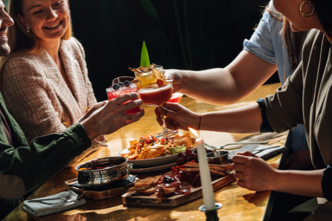 Friends toasting cocktails over tapas and small plates at a Reykjavík restaurant