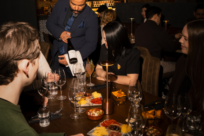 Guests enjoying wine and Icelandic appetizers in an elegant Reykjavík restaurant called Lóa Matur & Vín
