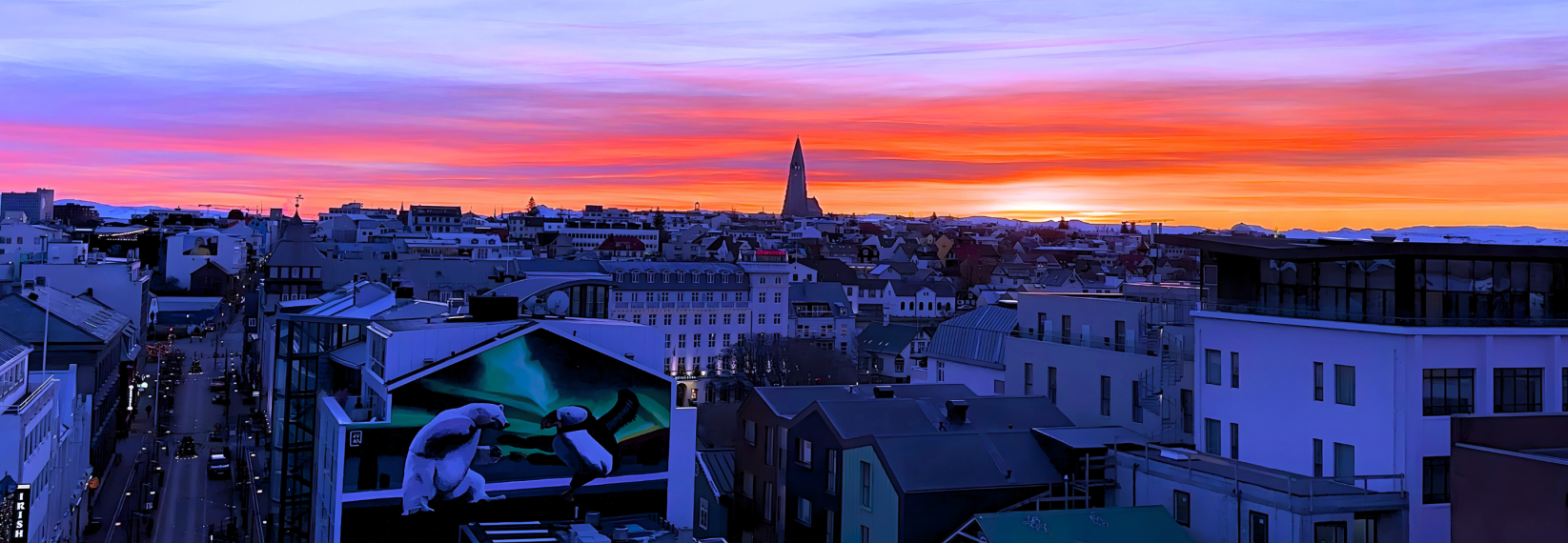 Colorful winter sunset over downtown Reykjavík with Hallgrímskirkja in the distance.