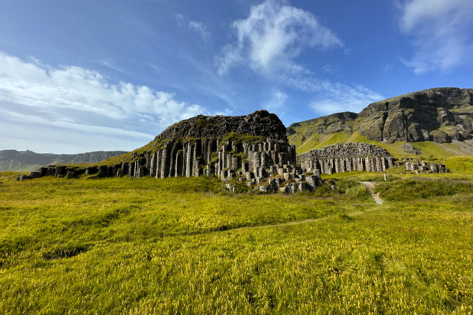 Unique basalt rock formations surrounded by green fields in Iceland