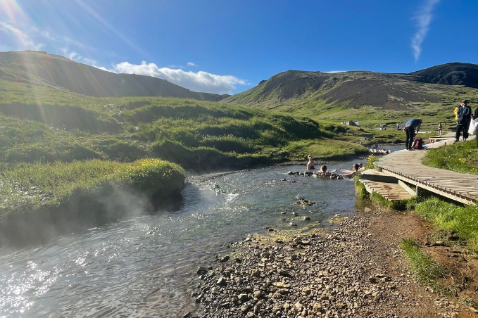 Reykjadalur hot spring river surrounded by mountains and green landscape in Iceland