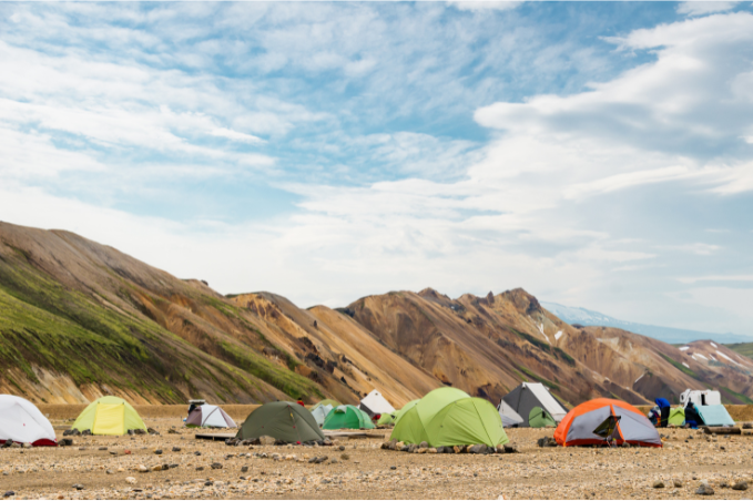 Colorful camping tents in Landmannalaugar surrounded by the rhyolite mountains of Iceland's Highlands.