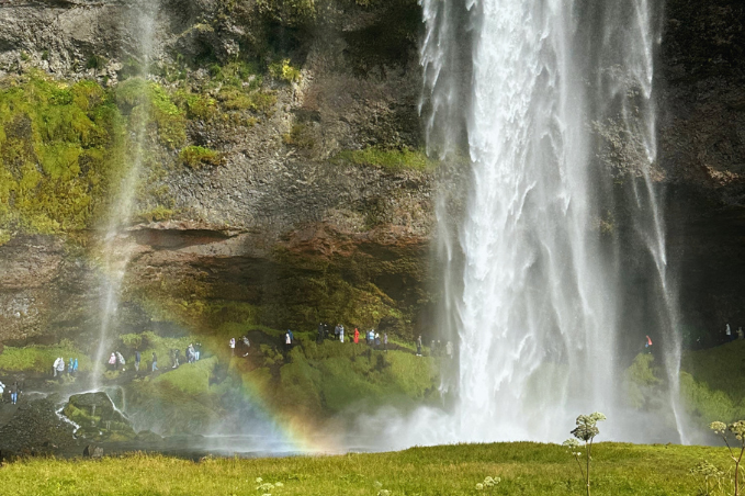 Seljalandsfoss waterfall in South Iceland with a rainbow at the base