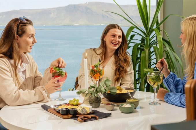 Friends enjoying drinks and food at SKÝ Lounge & Bar with views over Reykjavík