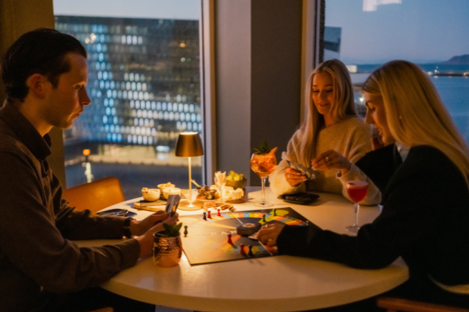 Guests enjoying drinks with a view of Harpa Concert Hall in Reykjavík