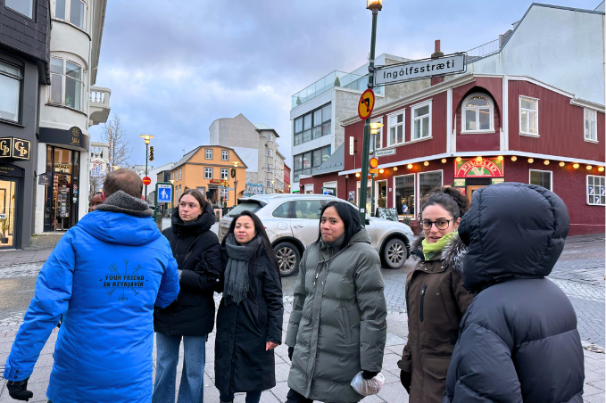 Visitors in warm coats gather around a guide on Ingólfsstræti during a Reykjavík walking tour.