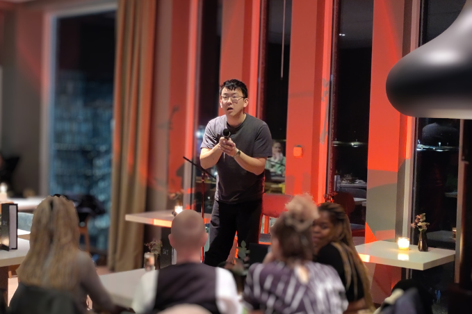 Stand-up comedian performing on stage in front of an audience at a comedy night in Reykjavík