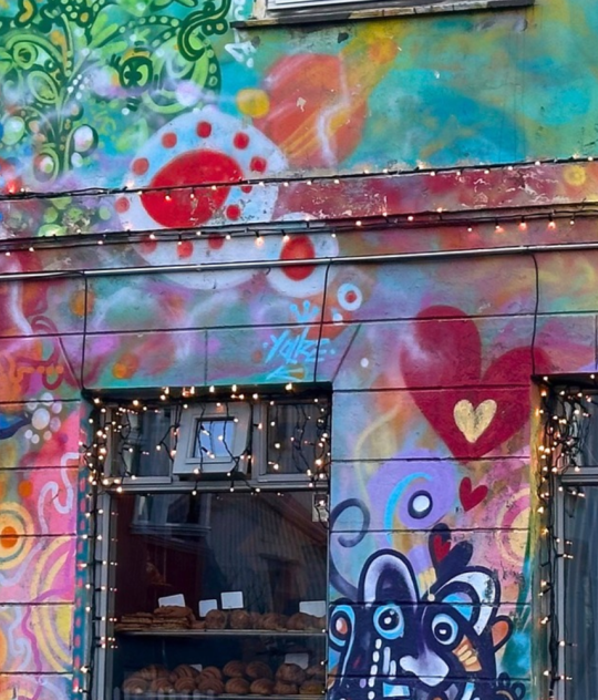 Brauð & Co bakery in Reykjavík, with vibrant murals of hearts, swirls and playful figures covering its façade.