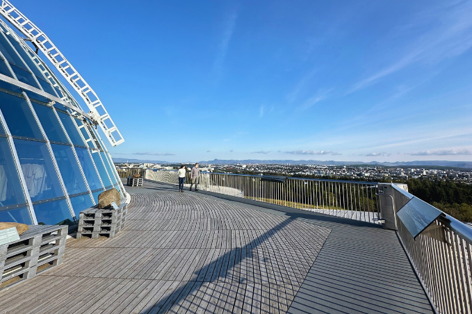Perlan observation deck overlooking Reykjavík under a clear blue sky.