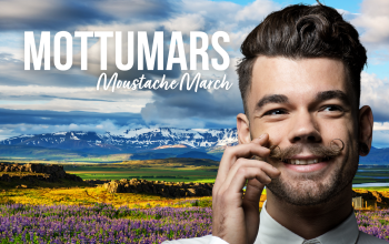 a smiling man twirling his moustache in front of a colourful Icelandic landscape