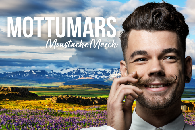 a smiling man twirling his moustache in front of a colourful Icelandic landscape